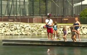 Children enjoying dockside fun at summer camp with attentive counselors by the water.
