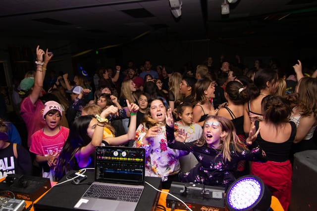 Children enjoying a lively dance party at a summer camp event, fostering fun and friendship. Children enjoying a lively dance party at a summer camp event, fostering fun and friendship.