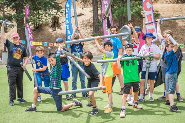 Kids engaged in fun outdoor activity at summer camp, holding foam swords on a vibrant field. Perfect for adventurous play. Kids engaged in fun outdoor activity at summer camp, holding foam swords on a vibrant field. Perfect for adventurous play.