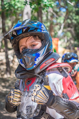 Child in motocross gear at summer camp, ready for adventure and outdoor fun. Child in motocross gear at summer camp, ready for adventure and outdoor fun.
