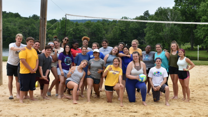 Group of happy campers at a summer camp volleyball court, enjoying outdoor activities and teamwork. Group of happy campers at a summer camp volleyball court, enjoying outdoor activities and teamwork.