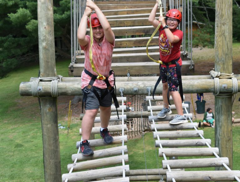 Kids enjoy a ropes course adventure at summer camp, promoting active fun and outdoor experiences. Kids enjoy a ropes course adventure at summer camp, promoting active fun and outdoor experiences.