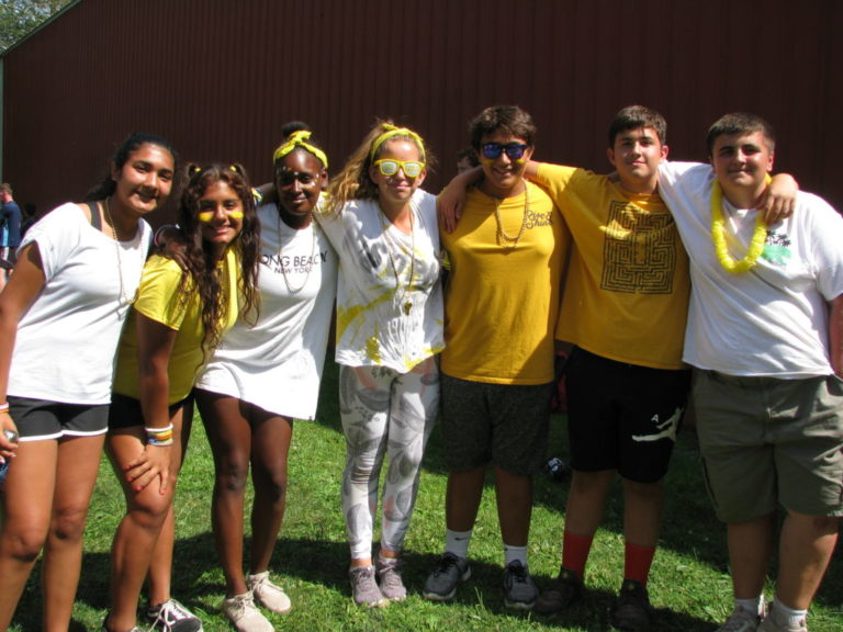 Group of happy campers enjoying a sunny day at a summer camp event in matching yellow and white outfits. Group of happy campers enjoying a sunny day at a summer camp event in matching yellow and white outfits.