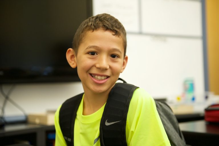 Smiling boy with a backpack at summer camp, ready for fun and learning. Perfect for camp directory website. Smiling boy with a backpack at summer camp, ready for fun and learning. Perfect for camp directory website.