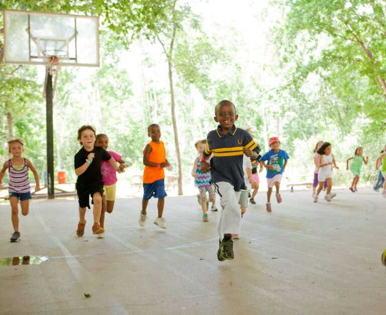 Kids enjoying outdoor activities at summer camp. Basketball court fun under the trees, smiles all around. Kids enjoying outdoor activities at summer camp. Basketball court fun under the trees, smiles all around.