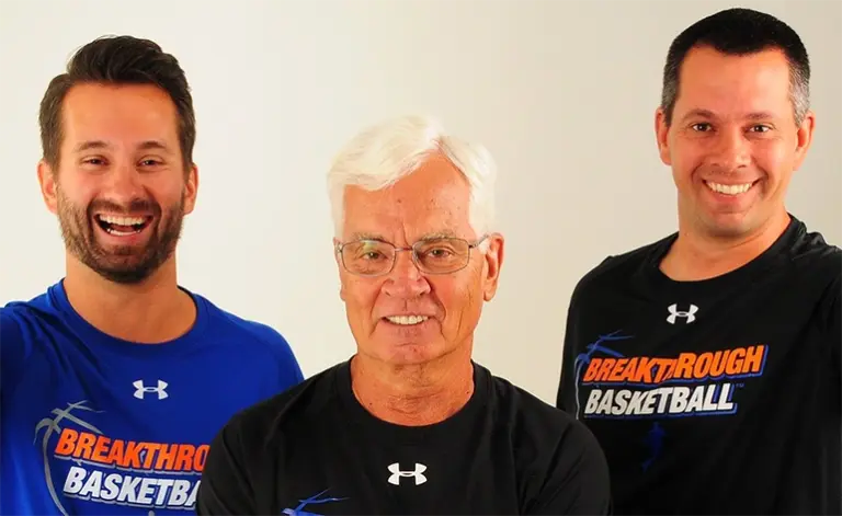 Three basketball coaches smiling at a summer camp, wearing Breakthrough Basketball shirts. Three basketball coaches smiling at a summer camp, wearing Breakthrough Basketball shirts.