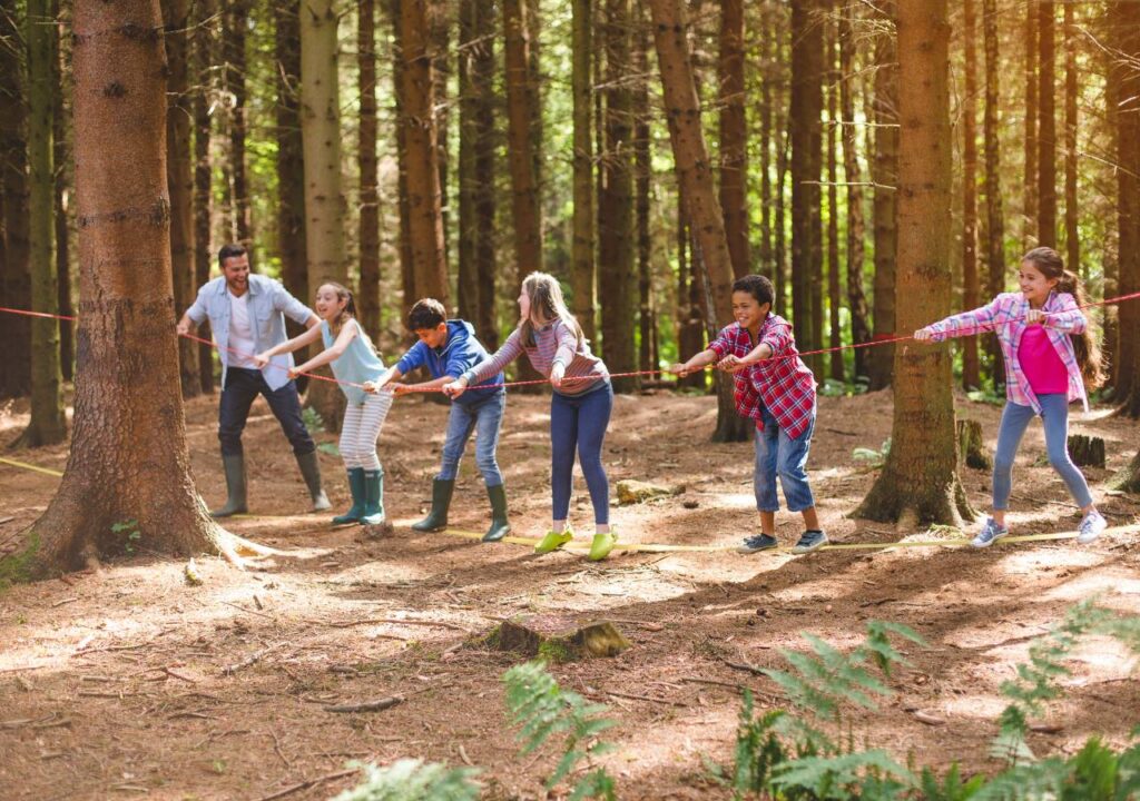 Kids playing a game in the woods during summer camp