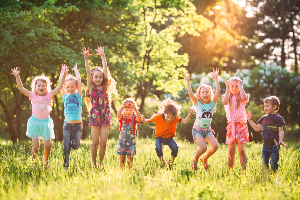 Children enjoying summer camp activities outdoors in a sunny field.