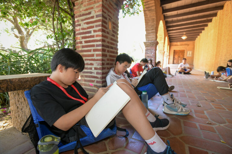 Kids engaged in outdoor sketching activity at summer camp, under a rustic archway. Ideal creative camp experience. Kids engaged in outdoor sketching activity at summer camp, under a rustic archway. Ideal creative camp experience.