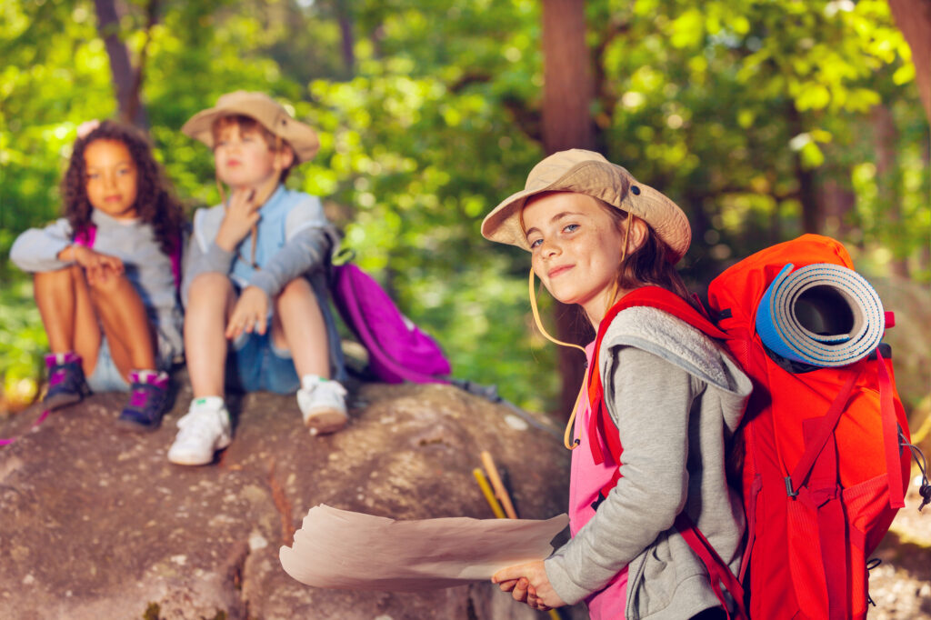 Kids enjoying outdoor adventure at summer camp, exploring nature and hiking in the woods.
