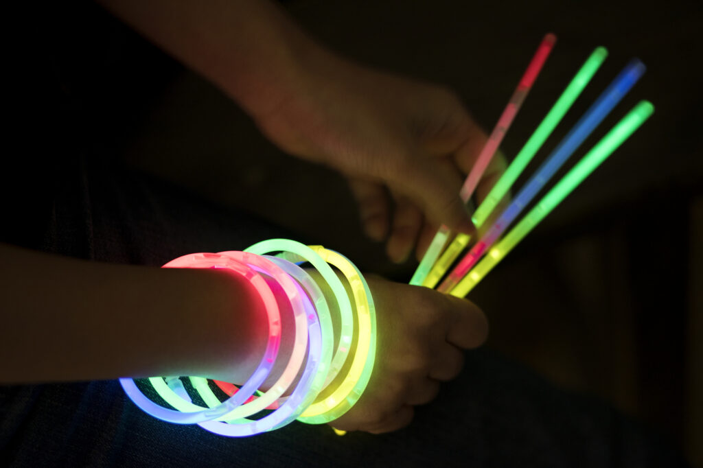 Colorful glow sticks and bracelets at a summer camp night event; perfect for kids' activities and fun.