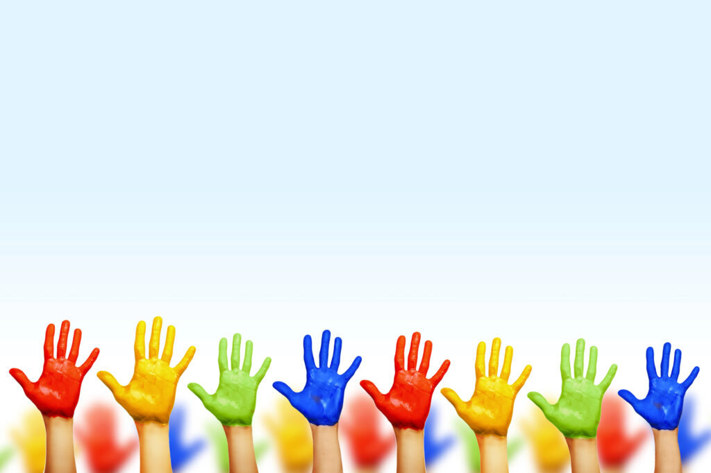 Colorful painted hands raised in air, showcasing creativity at summer camp activities for kids.