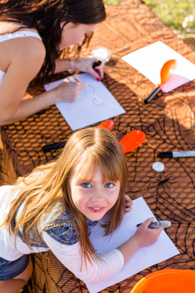 Child enjoying arts and crafts at summer camp, drawing outdoors on a sunny day.