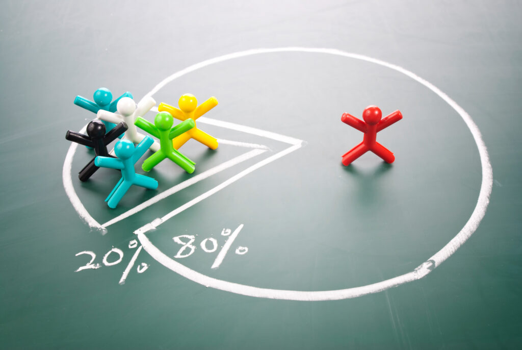 Diverse figurines on a chalkboard pie chart, illustrating group dynamics at a summer camp.