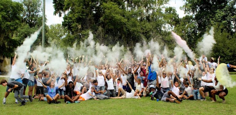 Group of campers having fun with colorful powder at summer camp outdoors. Group of campers having fun with colorful powder at summer camp outdoors.