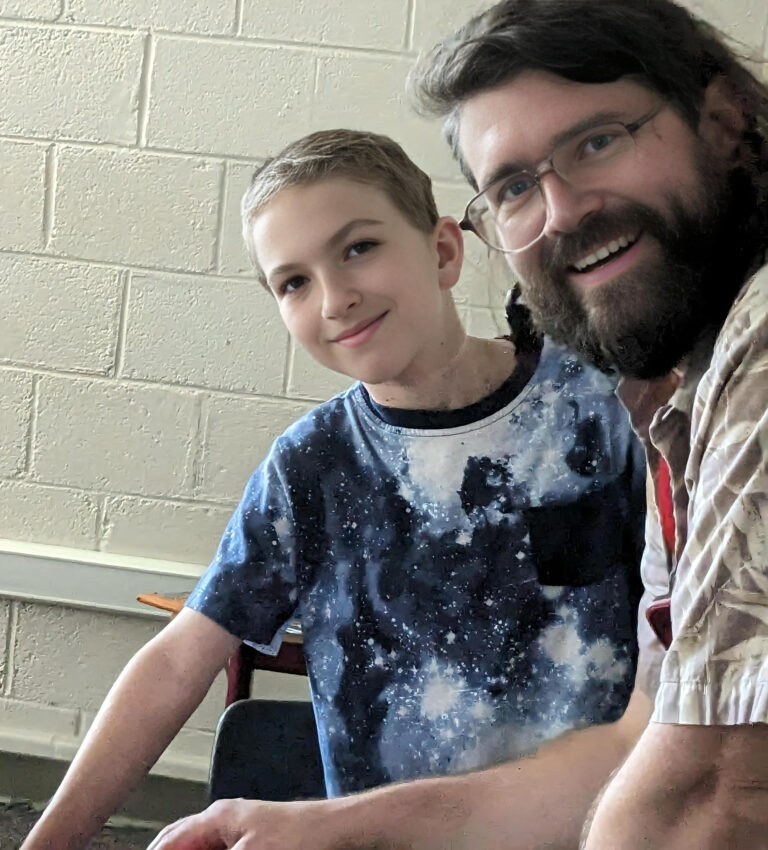 Child and counselor enjoy camp activities in classroom setting, showcasing the personal connections at summer camp. Child and counselor enjoy camp activities in classroom setting, showcasing the personal connections at summer camp.