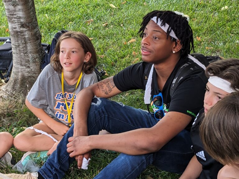Campers enjoy outdoor activities under a tree at summer camp. Discover your ideal summer adventure! Campers enjoy outdoor activities under a tree at summer camp. Discover your ideal summer adventure!