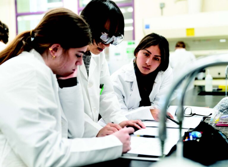 Students in lab coats during a science activity at a summer camp, engaged in collaborative learning. Students in lab coats during a science activity at a summer camp, engaged in collaborative learning.