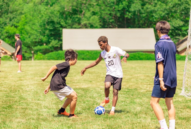 Kids playing soccer at a summer camp, enjoying the outdoors and learning teamwork on a sunny day. Kids playing soccer at a summer camp, enjoying the outdoors and learning teamwork on a sunny day.