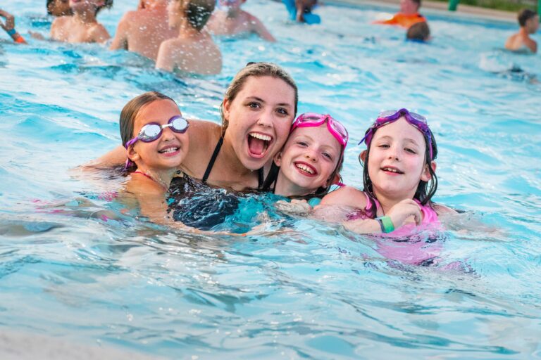 Kids enjoying a pool activity at summer camp, smiling and wearing goggles. Fun in the sun at camp swimming pool. Kids enjoying a pool activity at summer camp, smiling and wearing goggles. Fun in the sun at camp swimming pool.