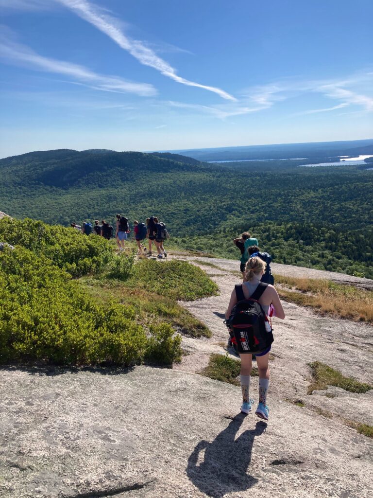 Group of campers hiking on a mountain trail with scenic views, perfect for outdoor adventures in summer camps. Group of campers hiking on a mountain trail with scenic views, perfect for outdoor adventures in summer camps.