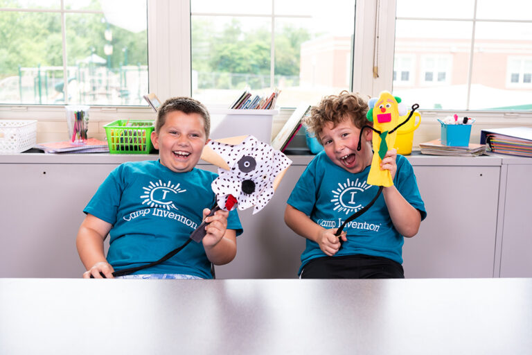 Children enjoying puppet crafts at Camp Invention, sparking creativity and fun learning. Summer camp activities.