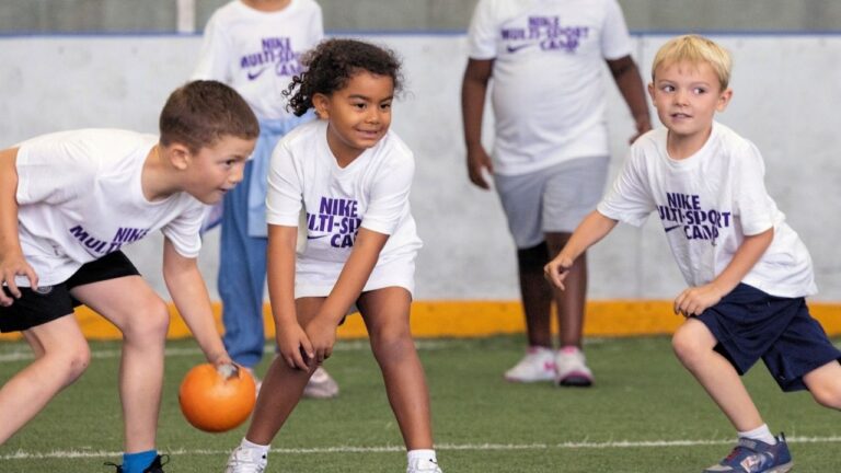 Kids playing dodgeball at a Nike multi-sport summer camp, fostering fun and teamwork.