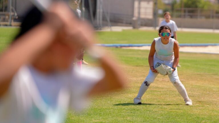Young athletes play softball at summer camp, showcasing teamwork and skills on the field.