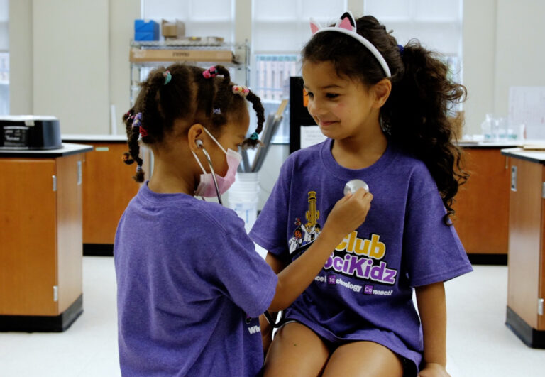 Children enjoying a medical science activity at summer camp wearing purple SciKidz shirts. Children enjoying a medical science activity at summer camp wearing purple SciKidz shirts.