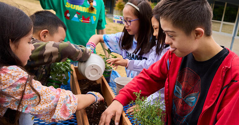 Children gardening at summer camp, learning teamwork and nature skills. Perfect for finding summer camps near you.