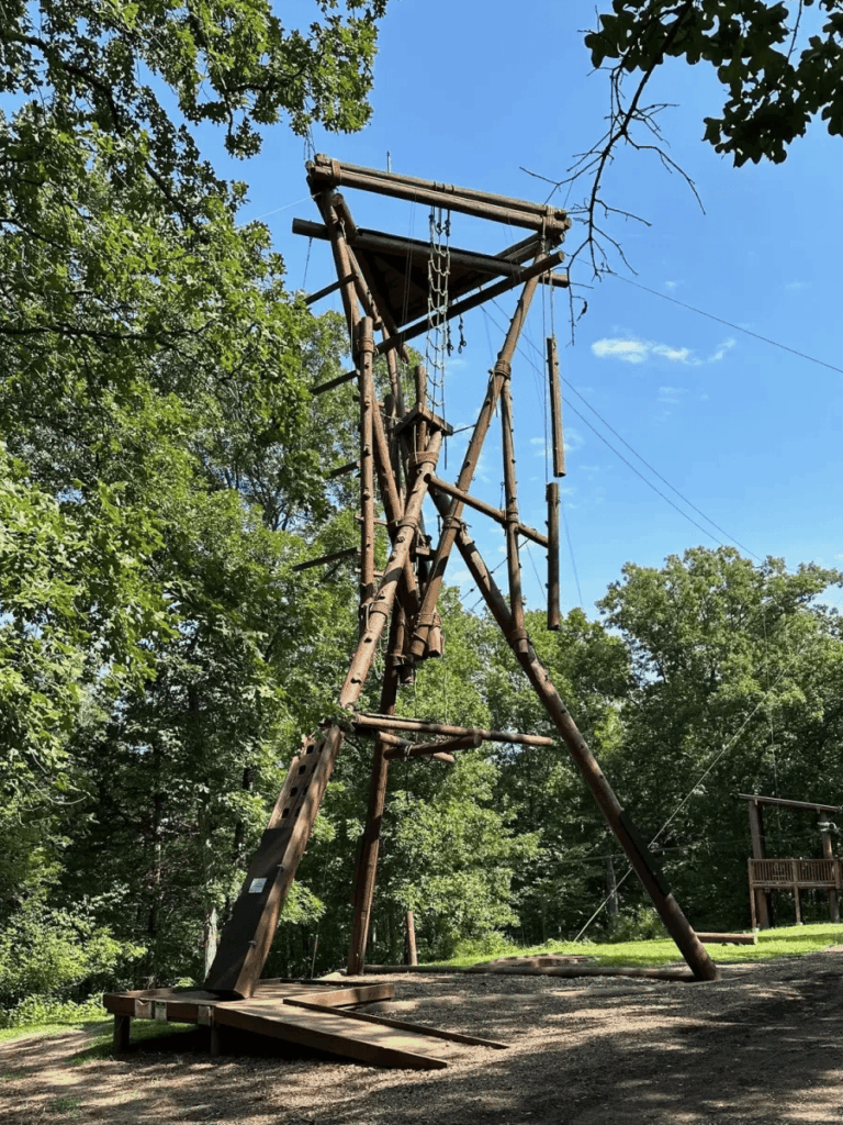 Tall wooden adventure course tower surrounded by lush trees at a summer camp, ideal for outdoor fun and challenges. Tall wooden adventure course tower surrounded by lush trees at a summer camp, ideal for outdoor fun and challenges.