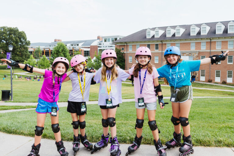 Kids enjoying rollerblading at summer camp, wearing helmets and safety gear, in front of campus buildings. Kids enjoying rollerblading at summer camp, wearing helmets and safety gear, in front of campus buildings.