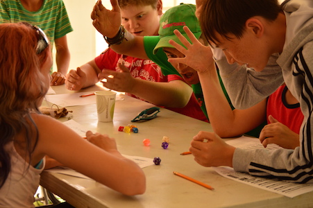 Kids engaged in fun tabletop games at summer camp, learning and bonding at an activity table. Kids engaged in fun tabletop games at summer camp, learning and bonding at an activity table.