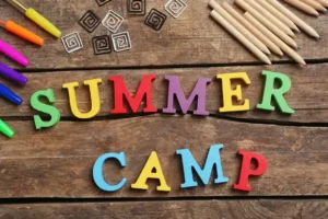 Colorful Summer Camp sign with pencils and art supplies, perfect for discovering fun camps.