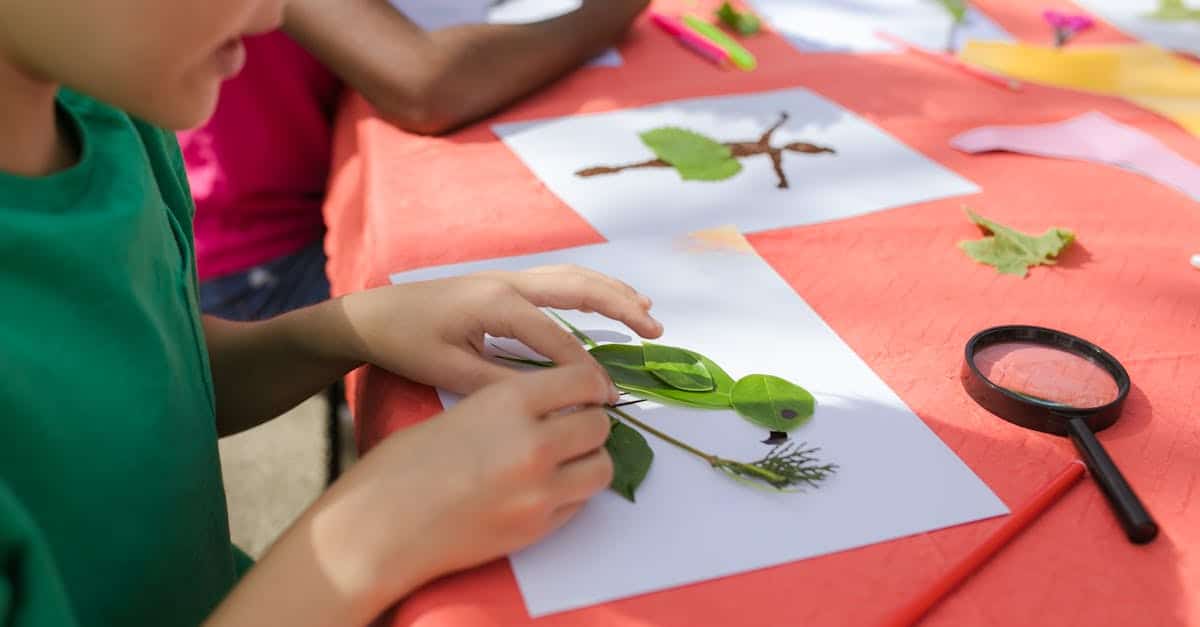 Child creating art with leaves at summer camp. Engaging craft activities in nature.