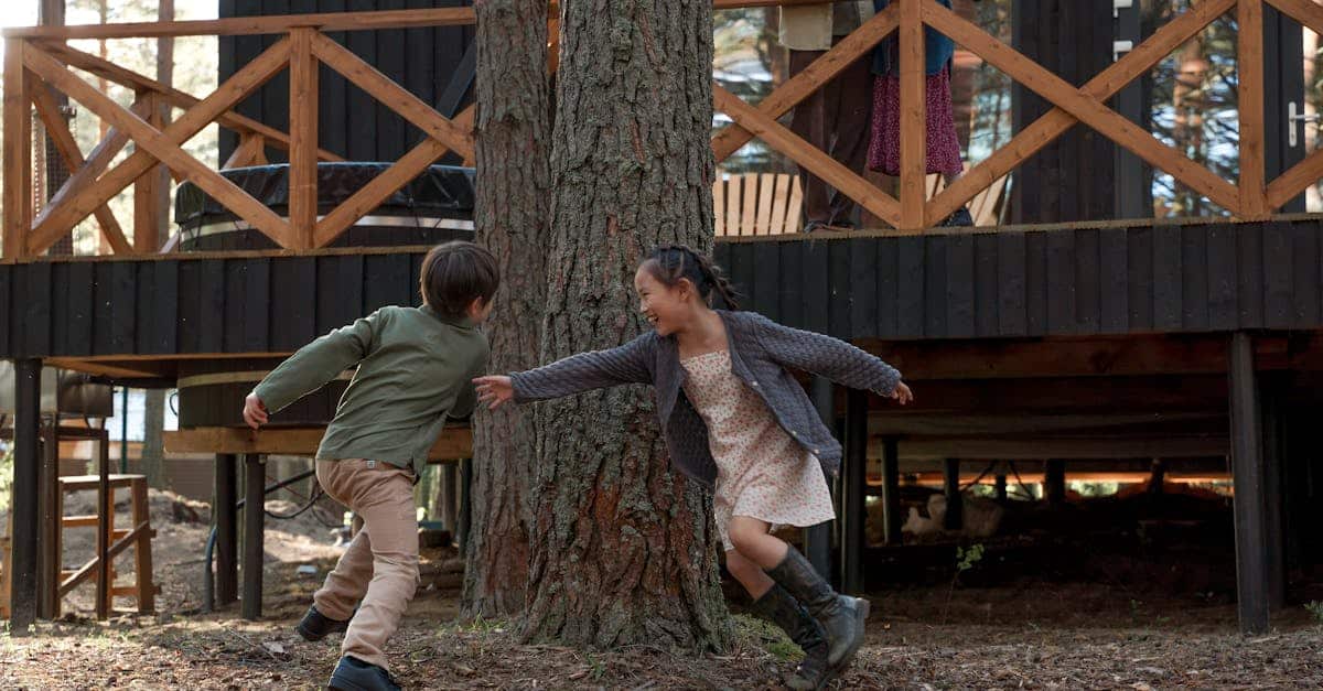Children playing tag at a summer camp, surrounded by nature and wooden cabins.
