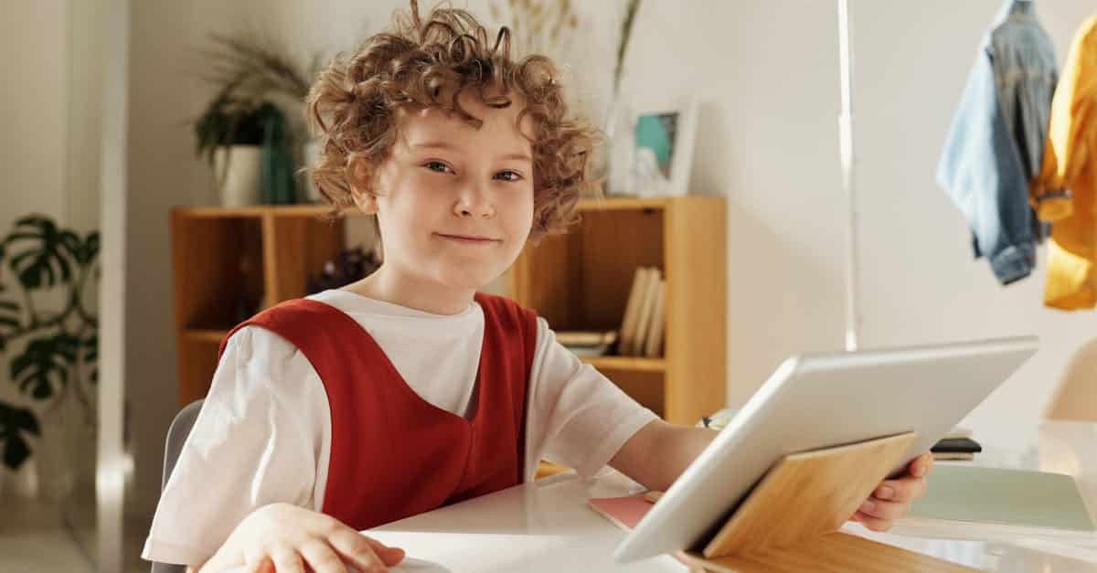 Happy child using a tablet at summer camp, exploring fun activities and learning new skills.