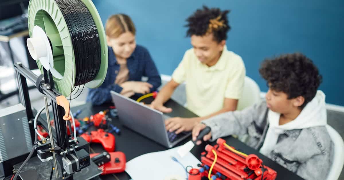 Kids engaged in a summer camp robotics workshop, working with 3D printer and laptop.