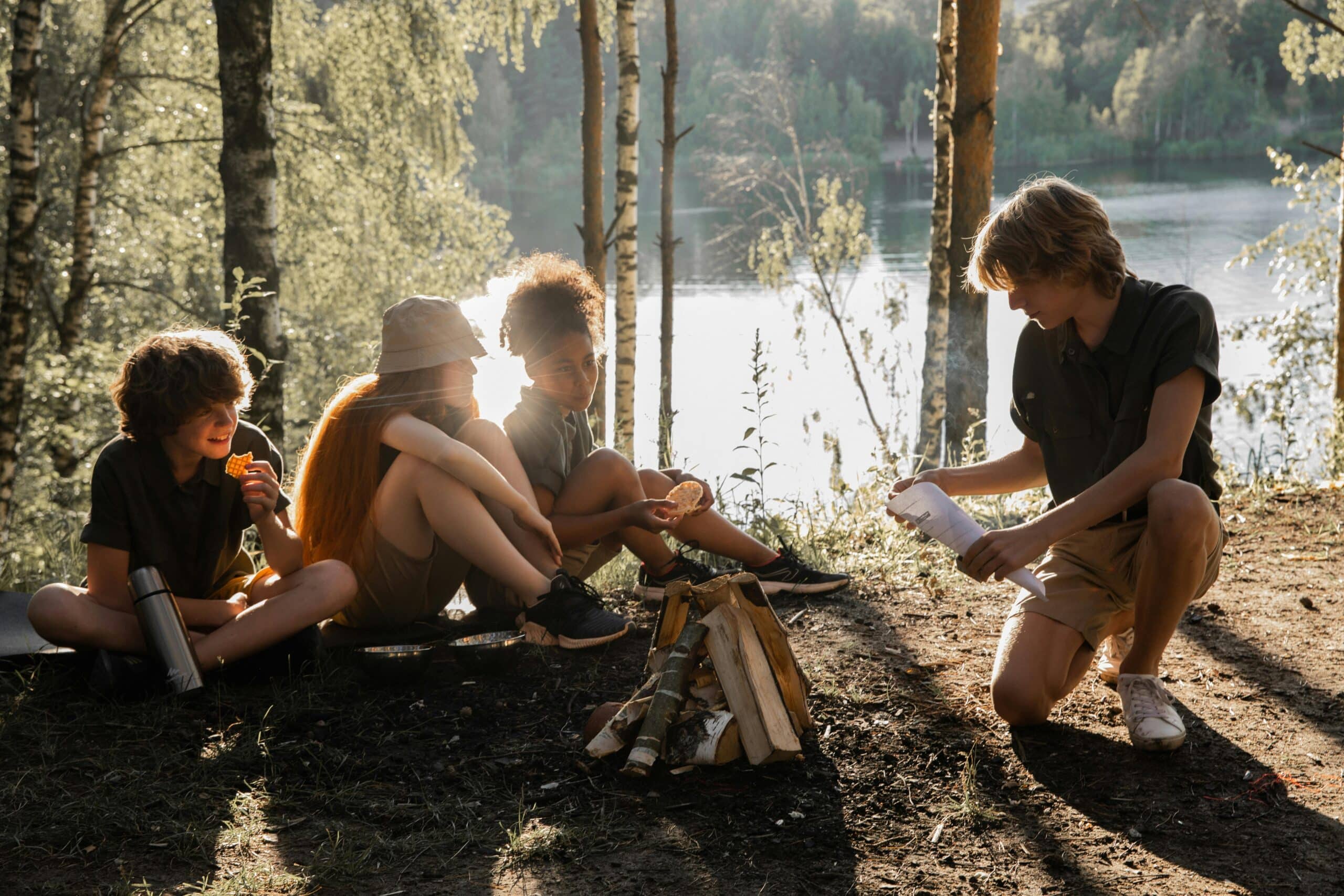 Kids enjoying campfire activities by a lake. Perfect summer camp experience with friends and nature.
