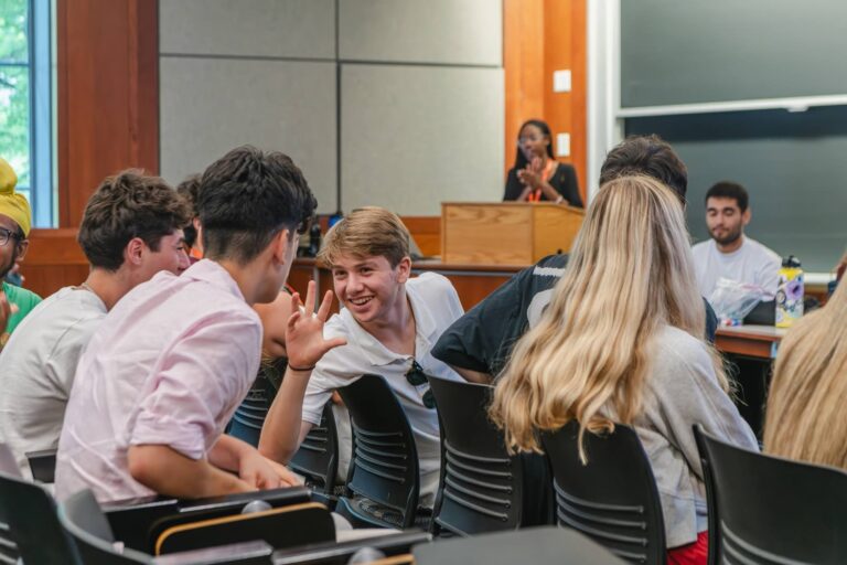 Teen campers chatting in a classroom workshop during a summer camp session, engaged and smiling Teen campers chatting in a classroom workshop during a summer camp session, engaged and smiling