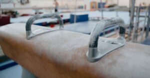 Gymnastics pommel horse in a summer camp gym, ready for training and competition practice for young athletes.